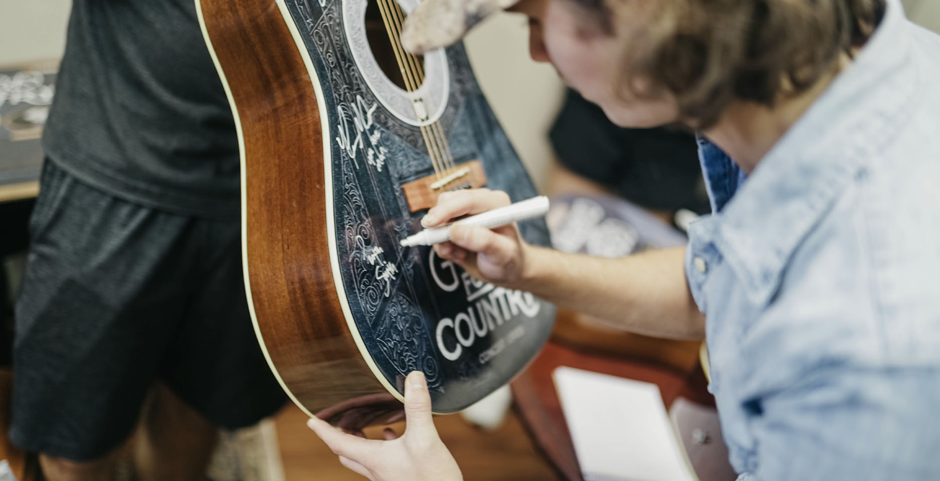 artist signing guitar